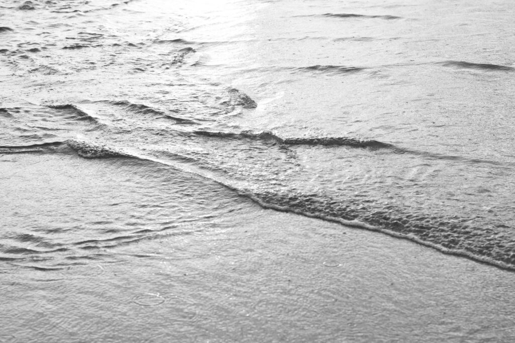 Black and white photo of very small ocean waves