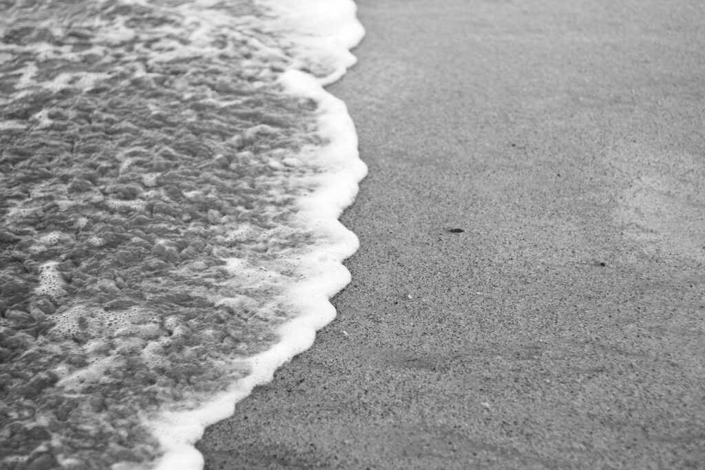 Black and white photo of a wave on the beach